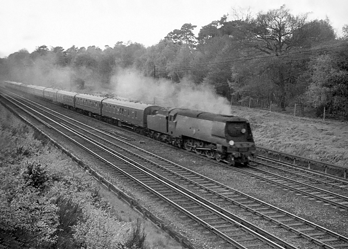 Photo of an orginal Bulleid West Country Class pacific hurrying an up Bournemouth to London, Waterloo train along between Milepost 31 and Pirbight Junction on the mid 1960s