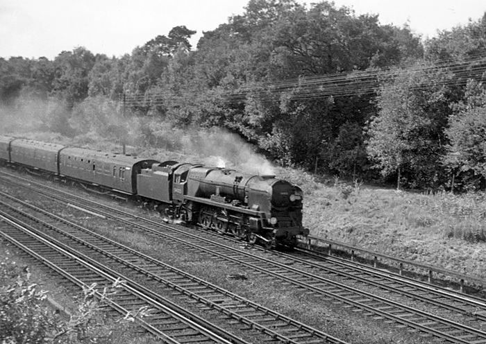 Photo of Bulleid West Country Class pacific number 34005, Barnstaple, heading an up train from Bournemouth to London, Waterloo, along the slow line between Milepost 31 and Pirbight Junction in the mid 1960s