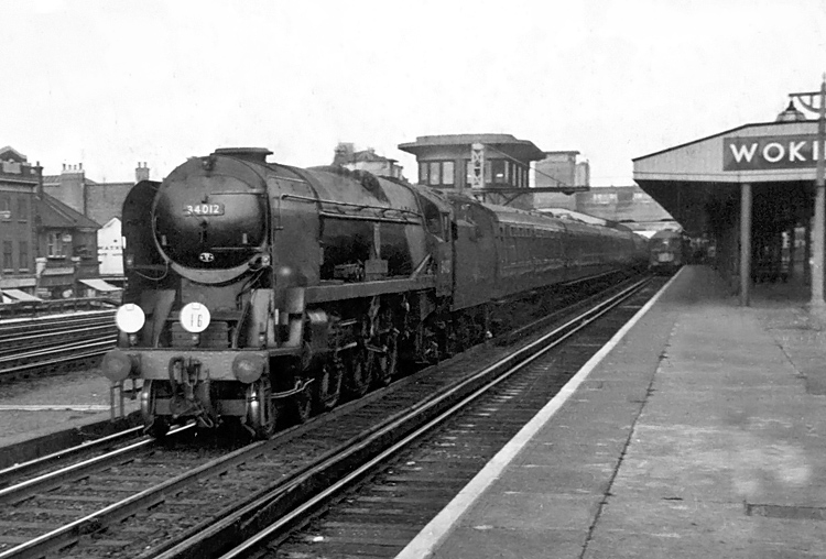 Photo of Bulleid West Country Class pacific number 34012, Launceston, working a train, that, from the headcode , is shown as a Waterloo or Nine Elms to Southampton Docks via East Putney, West through Woking in the mid 1960s