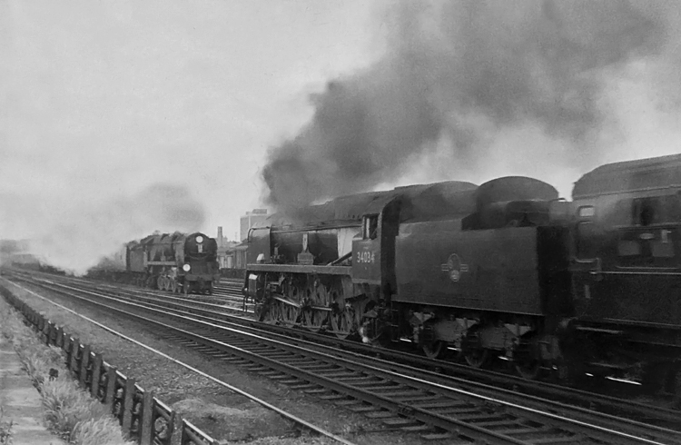 Photo of Bulleid West Country Class pacific number 34034, Honiton, heads towards Wimbledon station with an up train to London, Waterloo, meeting another Bulleid light pacific heading West with a special boat train to Southampton Docks via Millbrook in the mid 1960s