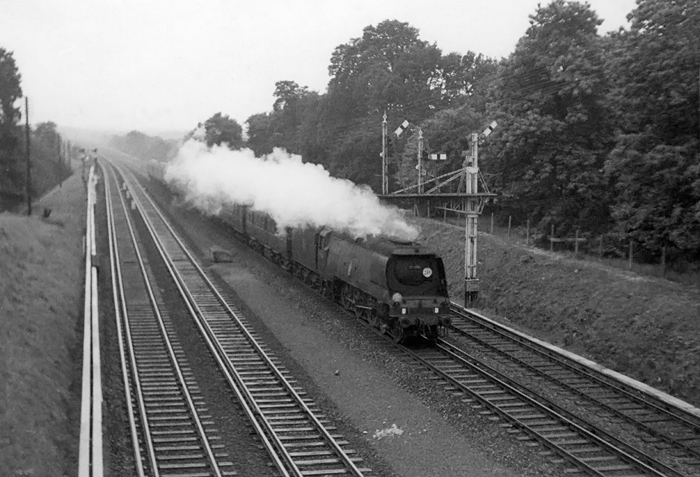 Photo of original Bulleid Battle of Britain Class pacific number 34051, Winston Churchill, on an up train from Bournemouth to London, Waterloo,  between Byfleet and Weybridge on 24th April 1962