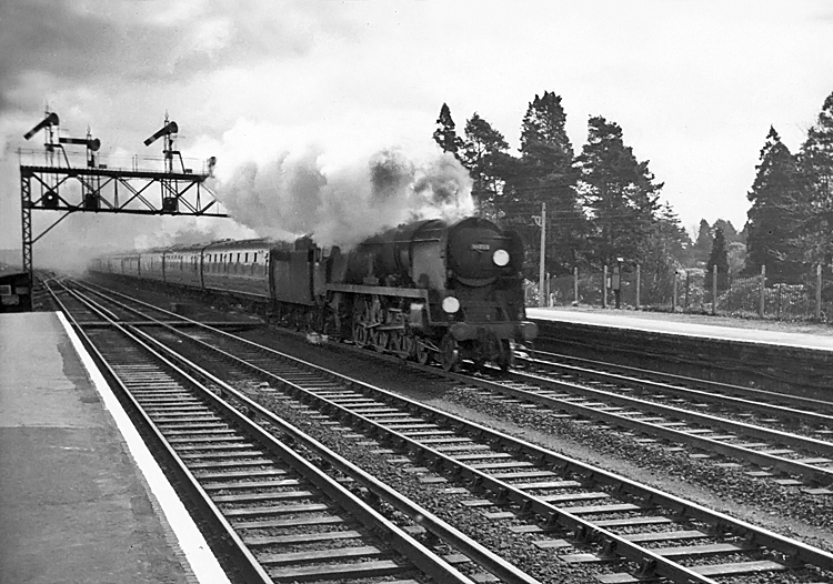 Photo of Bulleid Battle of Britain Class pacific number 34059, Sir Archibald Sinclair, passing Brookwood station at the head of a London, Waterloo to Bournemouth line train in the mid 1960s