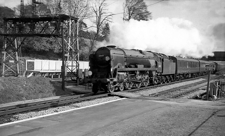 Photo of Bulleid West Country  Class pacific number 34101, Hartland, powers through Farnborough with a London, Waterloo to Bournemouth train in the mid 1960s