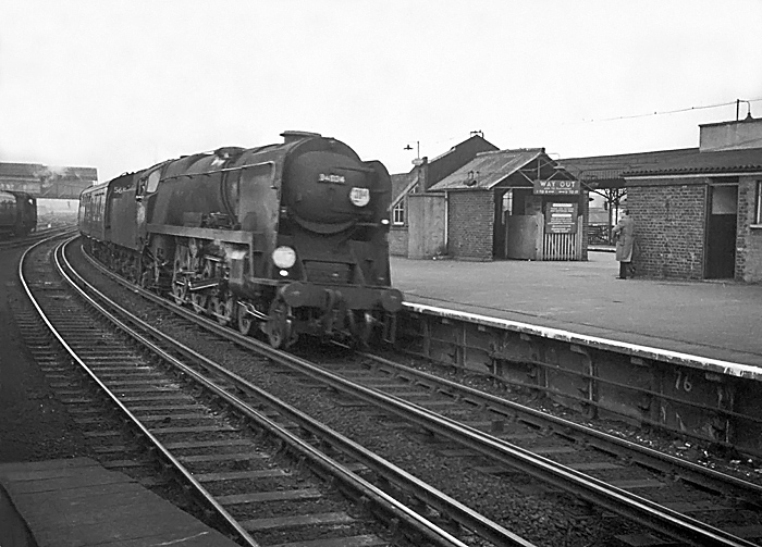 Photo of Bulleid West Country  Class pacific number 34104, Bere Alston, heading through Clapham Junction station with a London, Waterloo to Bournemouth train in the mid 1960s