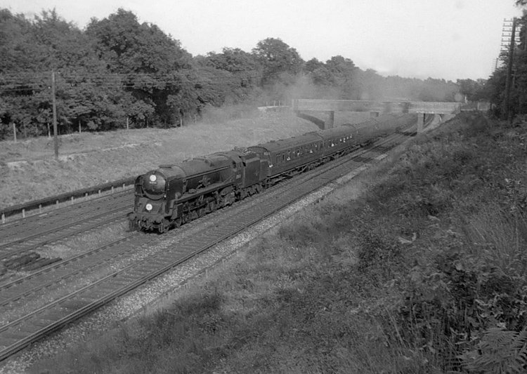 Photo of Bulleid Merchant Navy  Class pacific number 35026, Lamport & Holt Line heading under an overbridge and on towards Milepost 31 when heading a London, Waterloo to West of England train in the mid 1960s