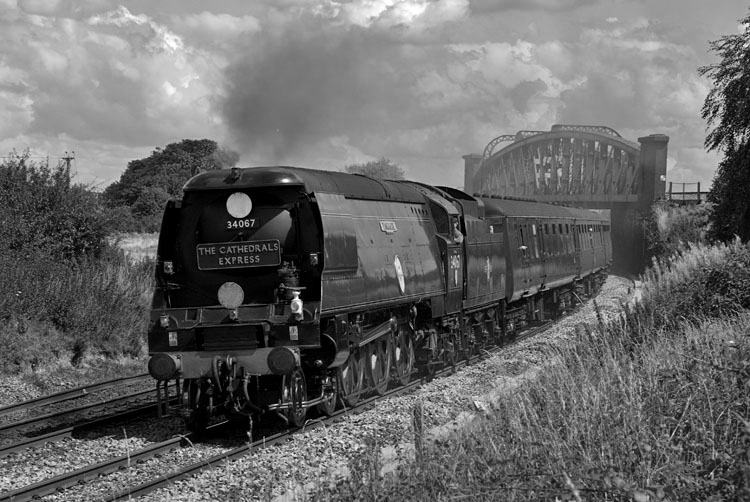 Photo of original Bulleid Battle of Britain Class pacific number 34067, Tangmere, heading a Steam Dreams Cathedrals Express from London, Victoria to Salisbury under the flyover at Battledown on 7th August 2008