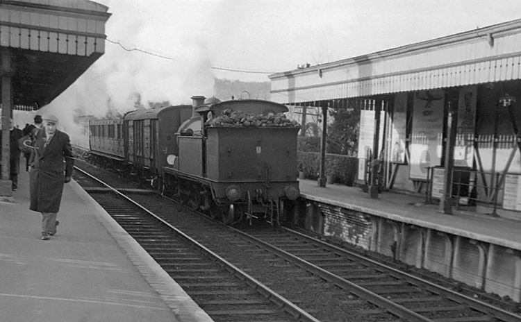 Photo of H class 0-4-4 tank loco number 31324 shunting into the down platform after running round the stock of the train it had recently hauled in from Tunbridge Wells West, circa April 1962