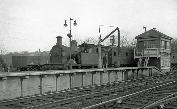 Photo of H class 0-4-4 tank loco number 31533 just after taking water at Oxted whilst working services to and from Tunbridge Wells West, circa April 1962