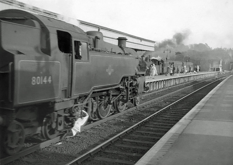 Photo of H class 0-4-4 tank loco in the bay platform at Oxted as BR class4 2-6-4 tank number 80144 arrives with a London to Brighton train, circa April 1962