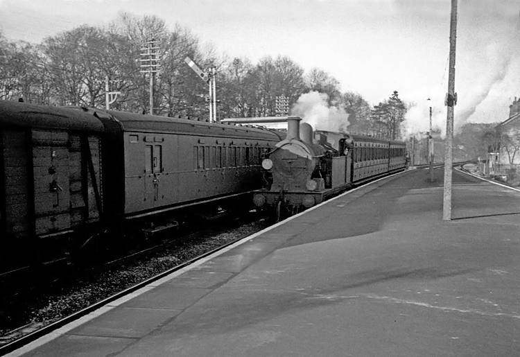 Photo of H class 0-4-4 tank loco arriving at Groombridge with a Tunbridge Wells to Oxted train,  and crossing what seems to be a U class 2-6-0 on a Brighton to Tonbridge train,  circa April 1962