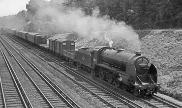 Photo of Maunsell S15 class 4-6-0 number 30837 on a heavy goods train climbing away from Woking Junction towards Brookwood in 1962-1963
