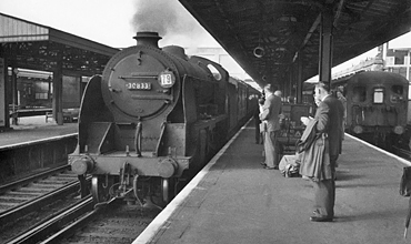 Photo of Maunsell S15 class 4-6-0 number 30833 arriving at Woking past a train of Bil units in the bay platform, when working an up Basingstoke local train for commuters in 1962-1963