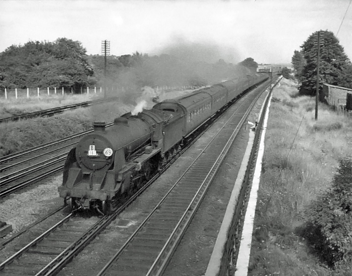 Photo of  Urie S15 class 4-6-0 number 30507 heads what is most likely an ecs train ex Waterloo to Basingstoke local train towards New Malden in 1962