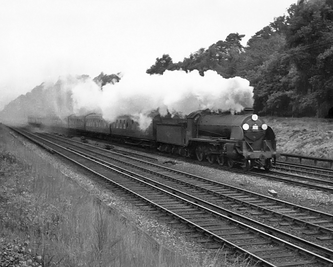 Photo of an Urie S15 Class 4-6-0 heading an up train from Lymington Pier to Waterloo, due 17.53,  between Milepost 31 and Pirbight Junction on 11th August 1962