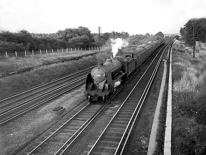 Photo of Maunsell S15 class 4-6-0 number 30834 heading a down train near New Malden in 1962-1963
