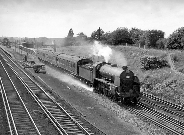 Photo of a  Maunsell S15 class 4-6-0 hurrying a very lightweight up Salisbury local train through New Malden in 1962-1963