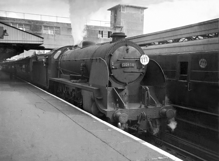 Photo of Maunsell S15 class 4-6-0 number 30838 on a down Basingstoke local train next to a Portsmouth line train of 4 CORS at Woking in 1962-1963