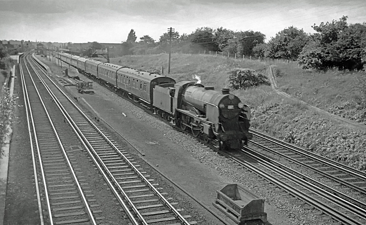 Photo of a Schools Class 4-4-0 30921 passing New Malden with an up train from Lymington Pier in summer 1962