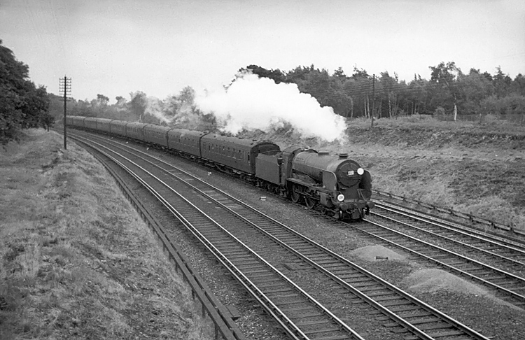 Photo of Schools Class 4-4-0 30906 on the 15.30 Waterloo to Bournemouth train between Pirbight Junction and Milepost 31 on 11th August 1962