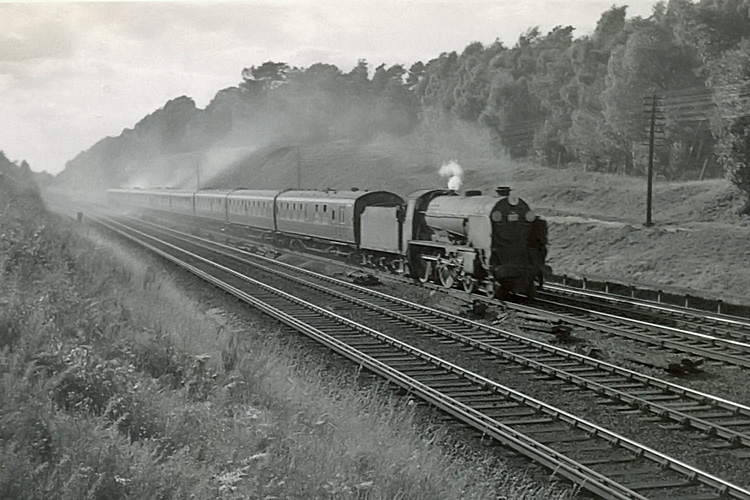 Photo of Schools Class 4-4-0 30936 on the 15.30 Lymington Pier to Waterloo train between Milepost 31 and Pirbight Junction in 25th August 1962