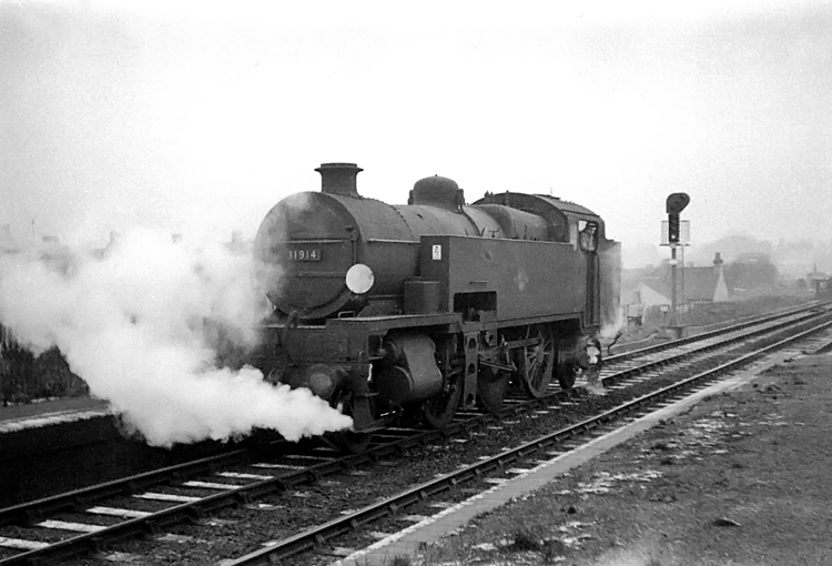 Photo of W Class 2-6-4 tank loco 31914 passing an Oxted line station near to Croydon in late 1961/62