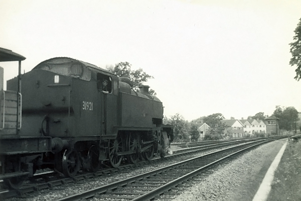 Photo of W Class 2-6-4 tank loco 31921 restarting from a signal stop approaching  Hurst Green Junction, on a goods train on the line from Brighton via Lewes and Uckfield. Spring 1962