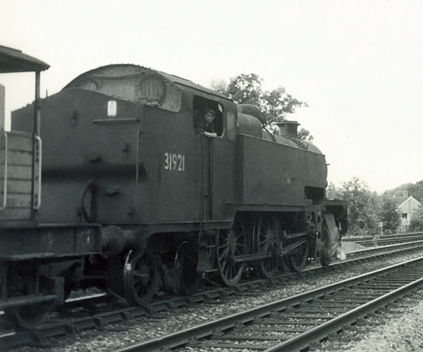 Photo of W Class 2-6-4 tank loco 31921 restarting from a signal stop approaching  Hurst Green Junction, on a goods train on the line from Brighton via Lewes and Uckfield. Spring 1962